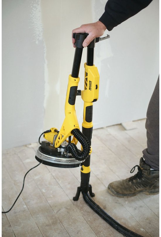 Gele telescoop schuurmachine met schuurkop, steel en steunvoet. Een persoon houdt de steel vast.