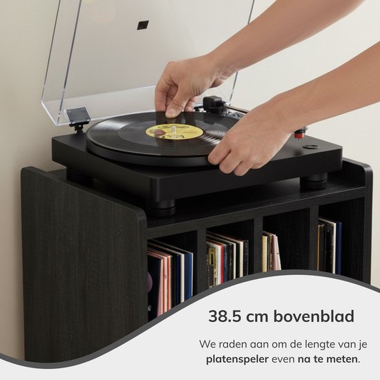 Zwarte platenspeler op een zwart meubel met vinylplaten in de vakken.