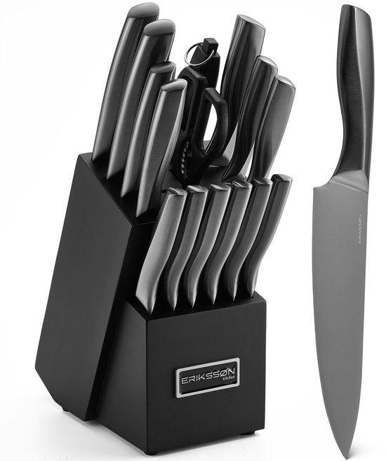 Zwart Erikssøn Kitchen messenblok met een selectie van zilverkleurige messen. Naast het blok ligt een koksmes met een zilverkleurig lemmet en zwart handvat.