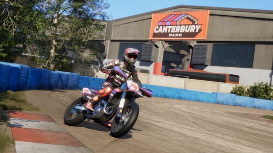 Coureur in rood, wit en zwart pak, op een rode en witte motor, bocht op Canterbury Park.