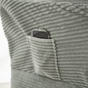 Lichtgroene corduroy stoel met een opgestikte zak waarin een telefoon ligt.