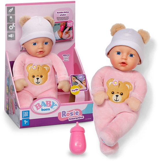 Baby Born interactieve pop Rosie, 30 cm, in roze pyjama met teddybeerprint, witte muts met oortjes. Roze drinkfles ernaast.