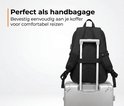 Zwarte rugzak bevestigd aan de handgreep van een zilverkleurige koffer.