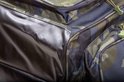 Dichtbij opname van de camouflageprint van de tas met de naden en glanzende stof.