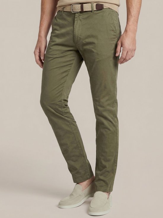 Man met olijfgroene chino's, een riem en beige instappers.