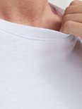 Detail van de ronde hals van een wit T-shirt met de hand van een man.