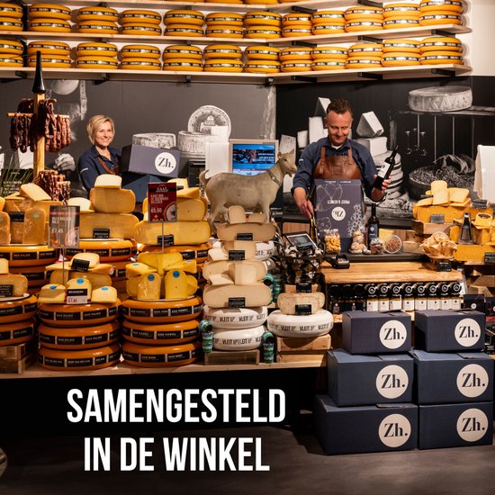 Een winkel met veel kazen, worsten en cadeauboxen. Twee verkopers staan achter de toonbank.