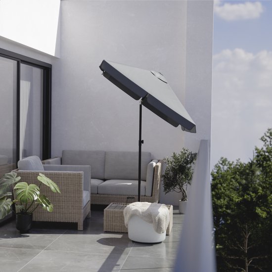 Donkergrijze parasol, half geopend, boven een balkon met loungeset en planten.
