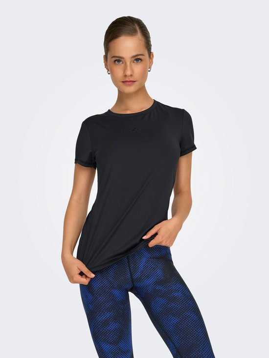 Model draagt zwart t-shirt met korte mouwen en ronde hals, gecombineerd met een blauw-zwarte legging.