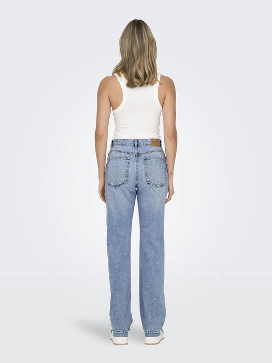 Vrouw in een witte tanktop en lichtblauwe straight leg jeans, rug zichtbaar.