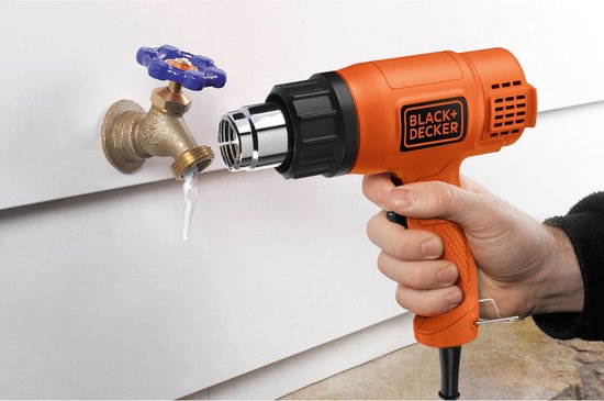 Oranje Black+Decker verfbrander met metalen mondstuk, gebruikt om water van een kraan te drogen.