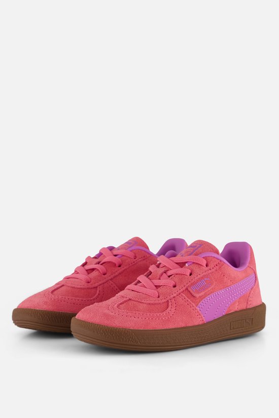 Paar roze suède Puma Palermo sneakers met paarse strepen en bruine zool.