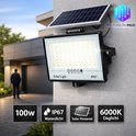 100W IP67 waterdichte zonneschijnwerper met daglicht (6000K), gemonteerd aan een muur naast een woning.