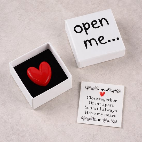 Rood hartvormig object in een open witte geschenkdoos met de tekst "open me...". Inclusief kaartje met tekst.