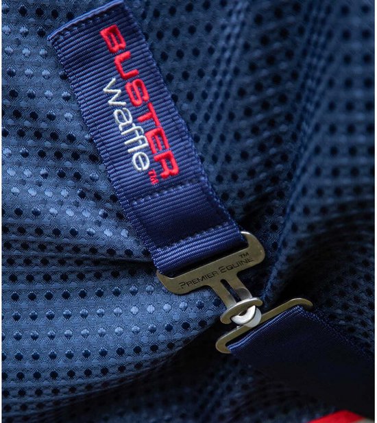 Detail van donkerblauwe paardendeken met 'BUSTER waffle' en 'PREMIER EQUINE' logo's en metalen sluiting.