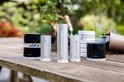Diverse Netatmo weerstation modules op een houten tafel in de tuin, waaronder een regenmeter, thermometer en anemometer.