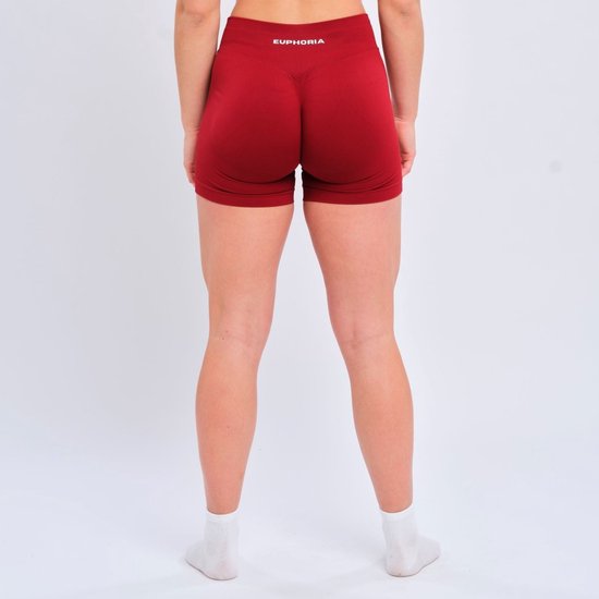 Achterkant van een vrouw in een rode sportshort met het Euphoria-logo op de tailleband.