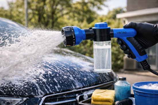 Hand met zwarte handschoen houdt blauwe Vintag schuimsproeier vast, spuit schuim op auto.