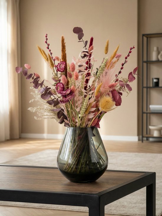 Gedroogde bloemen in warme tinten met roze, oranje, bruine en paarse accenten in een rookkleurige vaas.
