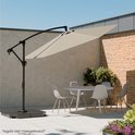 Een taupe cantilever parasol boven een tuintafel met stoelen, in een buitenruimte.