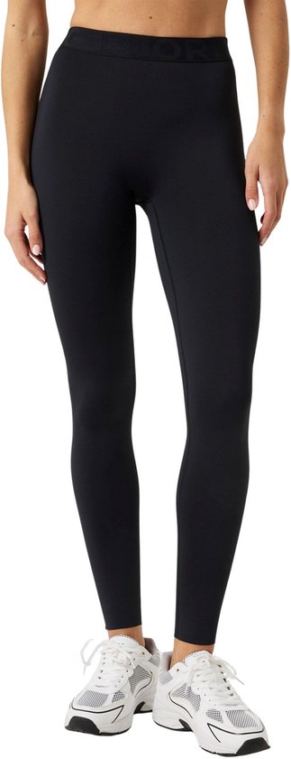 Model draagt zwarte legging en witte sneakers, voorkant zichtbaar.