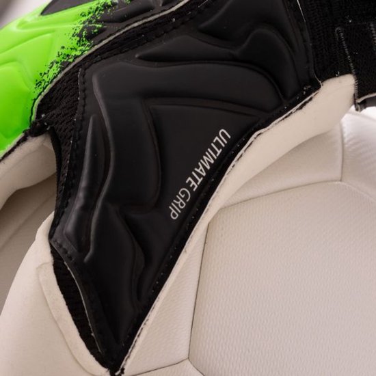 Detail van een doelmanhandschoen met de tekst "ULTIMATE GRIP" en zwarte beschermende elementen.