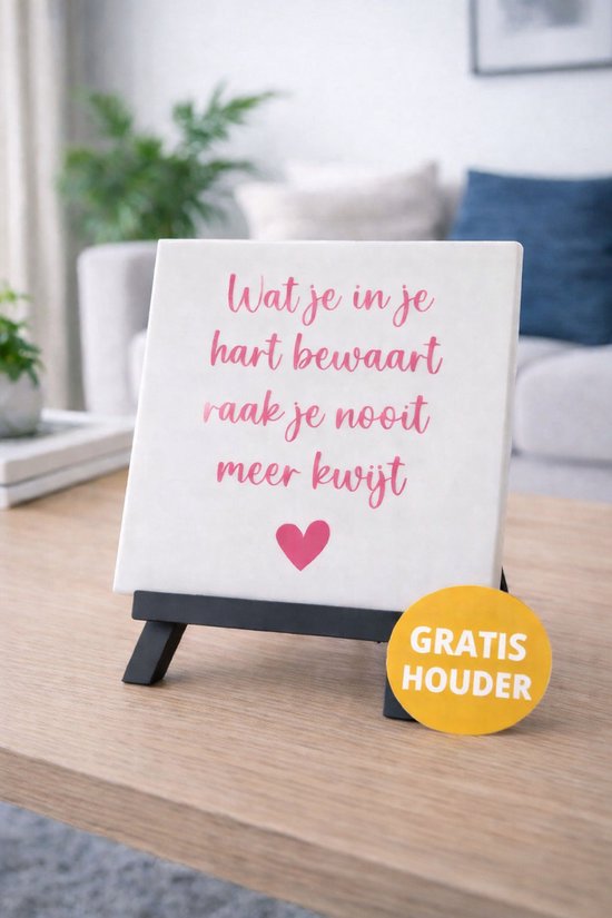 Carreau blanc avec texte rose 'Ce que tu gardes dans ton cœur, tu ne le perds jamais' et un cœur, sur un support.