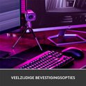 Webcam Logitech StreamCam sur un trépied, à côté d'un clavier et d'une souris, avec un éclairage violet.