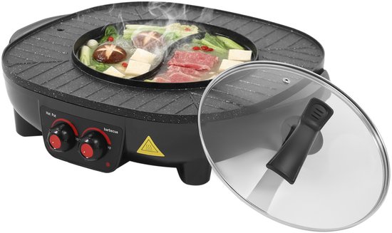 Zwarte elektrische hotpot met dampende hotpot met vlees en groenten, en gegrild vlees en groenten op de grillplaat. Glazen deksel ernaast.