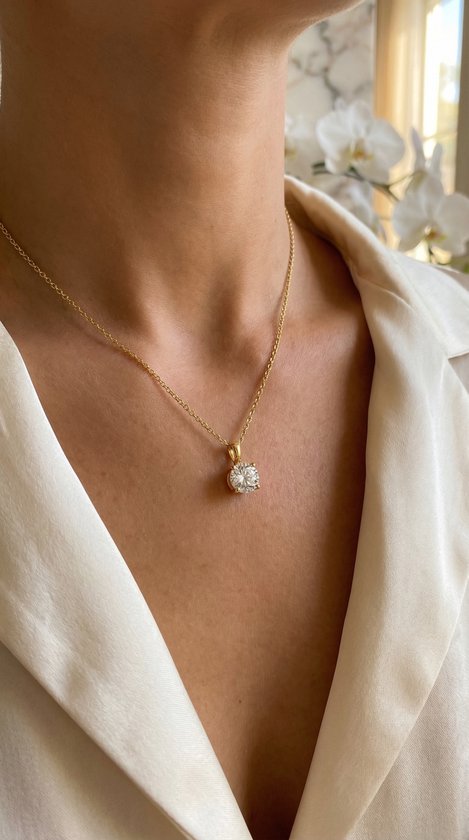 Gouden ketting met een schitterende zirkonia hanger gedragen door een vrouw.