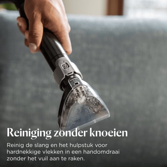 Een hand houdt een opzetstuk van de BISSELL HydroSteam, met waterdruppels en vuil.
