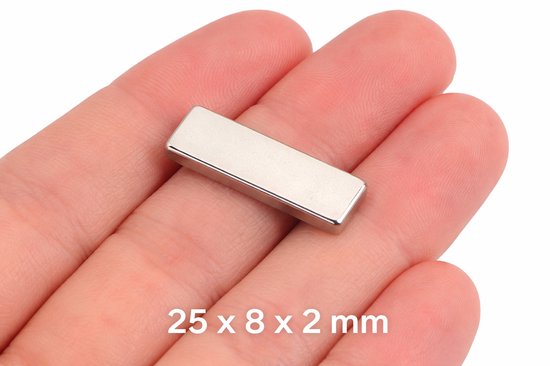Vinger in een hand houdt een zilverkleurige blokmagneet vast met de afmetingen 25x8x2mm.