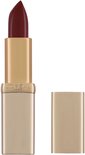 Gouden huls met een diep bordeauxrode lipstick punt. De zilveren dop ligt ernaast.