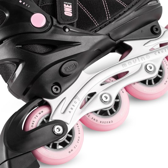 Zwarte skeelers met roze wielen, witte schacht en "PUSH"-knop voor maatverstelling.