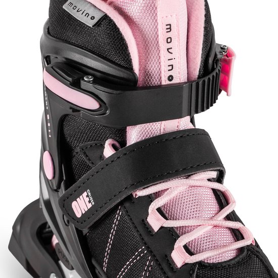 Detail van zwarte en roze skeelers met klittenband, roze veters en gespen.