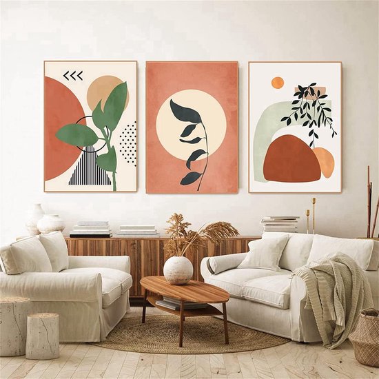 Trois affiches dans des tons terre cuite avec des feuilles et des formes abstraites au-dessus d'un salon.