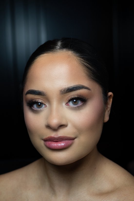 Portret van een vrouw met grijze contactlenzen, gladde huid en natuurlijke make-up.