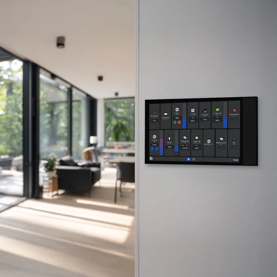 Zwart Shelly Wall Display XL met veel icoontjes en informatie, gemonteerd op een lichte muur in een moderne woonkamer met grote ramen.