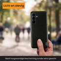 Coque de téléphone noire avec porte-cartes, tenue à la main, avec un arrière-plan flou.
