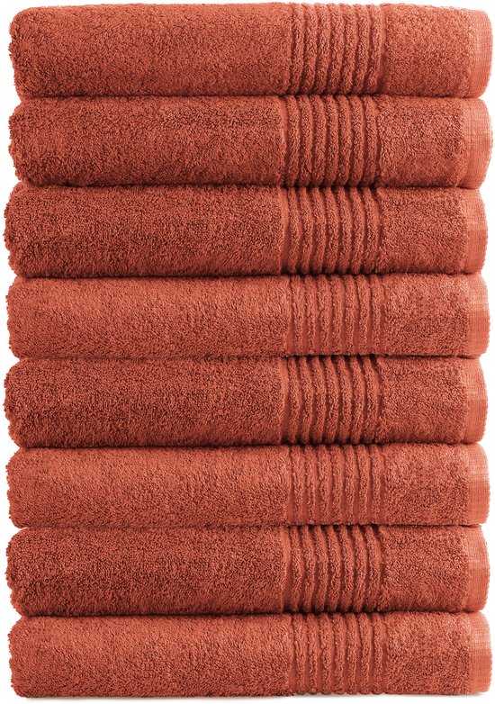 Pile de huit serviettes couleur terre cuite avec motif côtelé sur un côté.