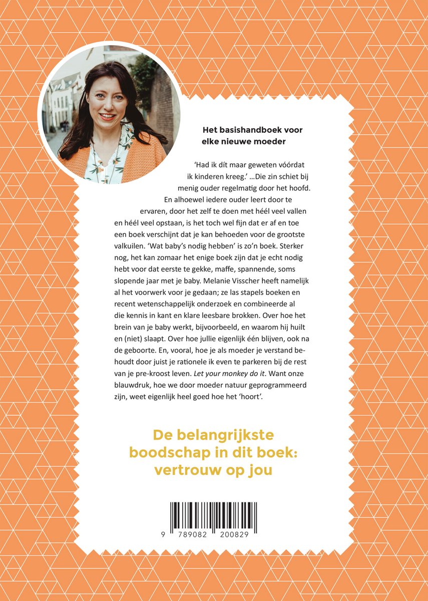 Een vrouw met bruin haar, staand, lacht naar de camera. Ze draagt een beige gebreide jas over een blouse met bloemenprint.