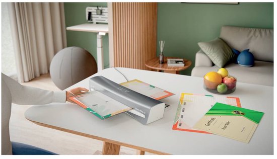 Leitz Home Office A3 lamineermachine in gebruik aan een bureau in een moderne woonkamer.