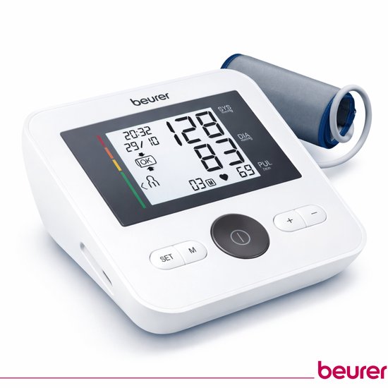Witte Beurer bloeddrukmeter met grote digitale cijfers op het scherm. Geborsteld metalen manchet ligt ernaast.