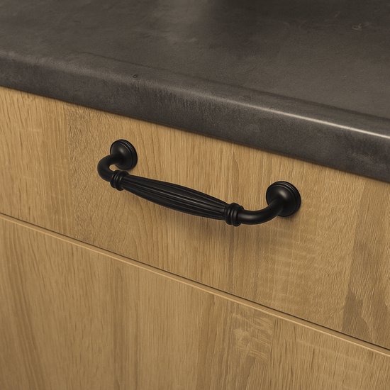 Zwarte boogvormige handgreep met geribbelde greep, gemonteerd op een houten lade.