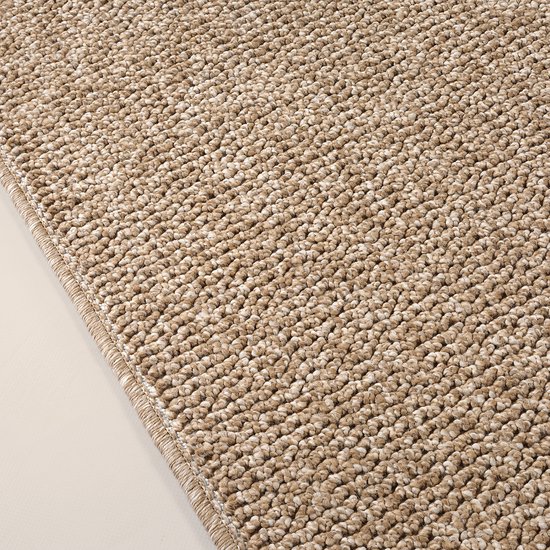 Gros plan d'un tapis brun à l'aspect jute avec un bord tressé.