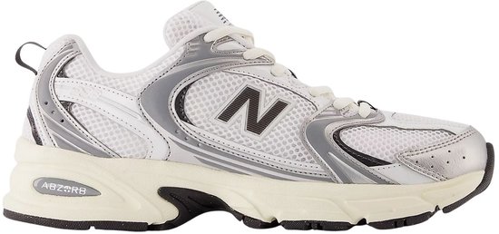Zijzicht van een witte New Balance 530 sneaker met zilveren en zwarte details.