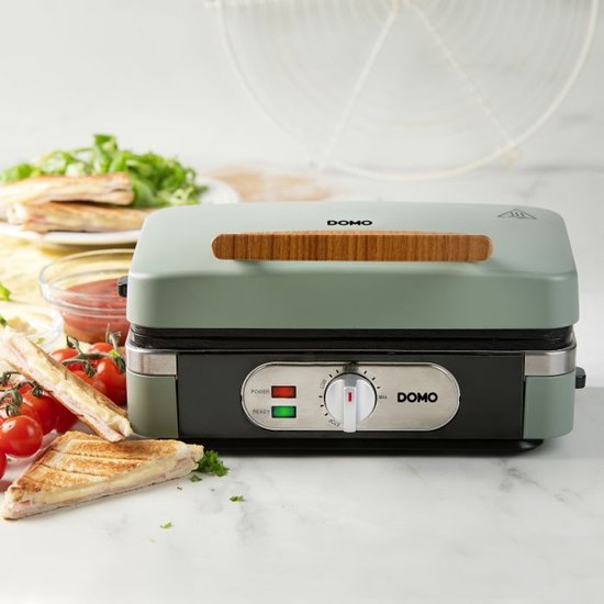 Groene DOMO grill met gesloten deksel, met een tosti op het aanrecht.