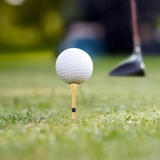 Een golfbal op een houten tee met zwarte strepen, op een groene grasmat.