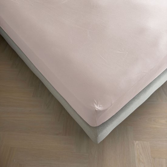 Drap-housse gris argent sur un lit avec un cadre en tissu, sur un parquet.