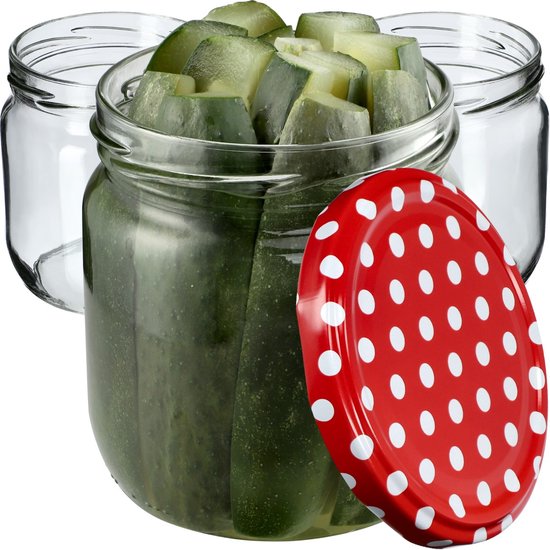 Bocal en verre avec des cornichons, un couvercle rouge à pois blancs, 2 bocaux vides à côté.